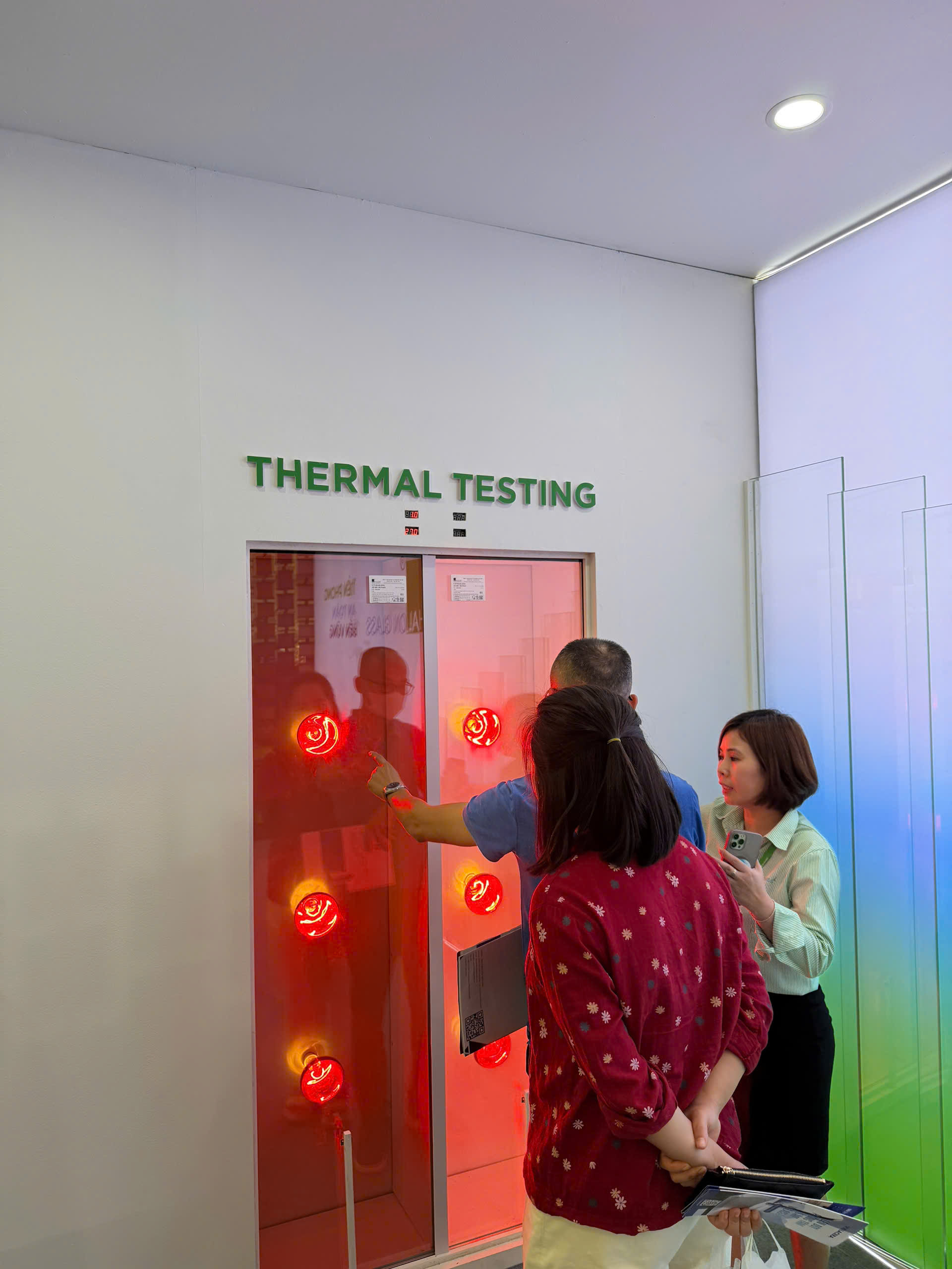Nhân viên giới thiệu hệ thống thermal testing với dàn đèn nhiệt đỏ trong phòng thí nghiệm